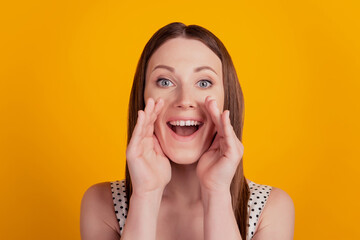 Portrait of positive announcer lady talk palm open mouth on yellow background