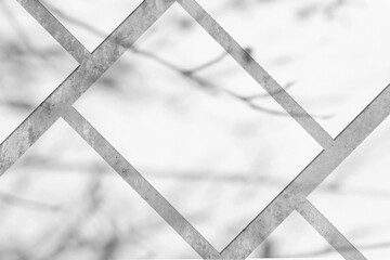 Many empty white vertical rectangle poster or card mockups lying diagonally with soft tree leaves and branches shadows on neutral light grey concrete wall background. Flat lay, top view