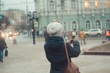 a girl in a winter hat walks around the city