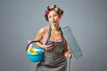 Comical female washer wear hair rollers and apron holding mop. Funny housewife cleaning around with...