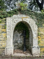 Fototapeta na wymiar Fentonluna Well Fentonluna Lane Padstow Cornwall a restored pump within well house set into deer park walls with a granite arch dated 1592 set on site of original well which served the early priory