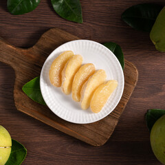 Fresh pomelo fruit on dark wooden table background.