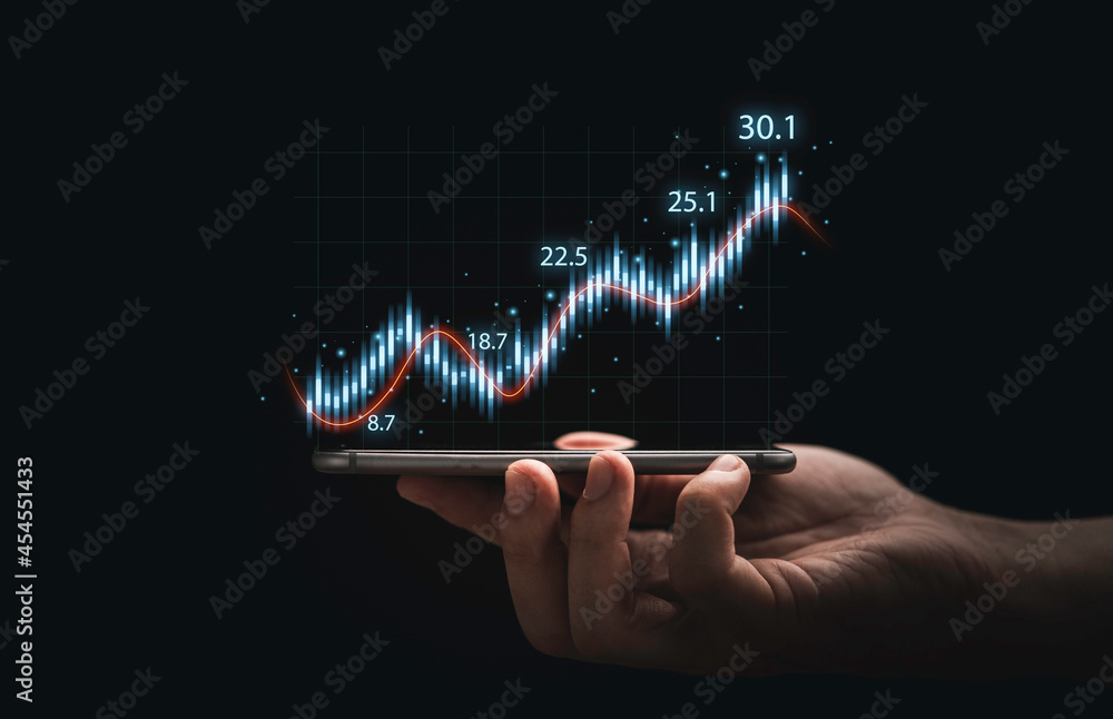 Poster trader hand holding smartphone with stock market graph chart on dark background for technical invest