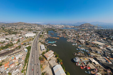Fototapeta premium Imágem aérea da ponte Rio Niterói com o pedágio, entroncamento do transito, zona portuária e estaleiros. Na divisa da cidade de Niterói e São Gonçalo, no estado do Rio de Janeiro Brasil.