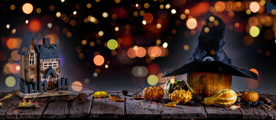 Halloween background with pumpkins, candles on wooden table and bokeh