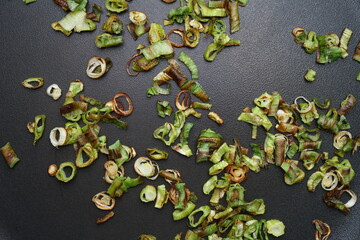 spring onion ingredient rings being roasted in coconut oil pan