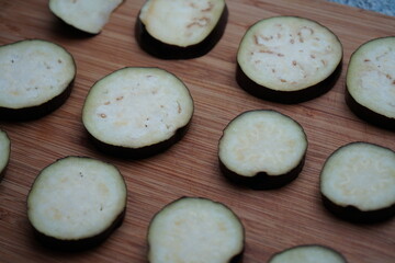 vegan eggplant slices lined up on wooden cutting board