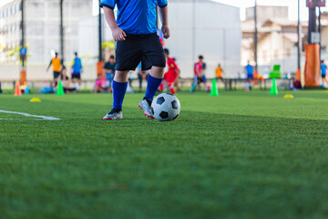 Children playing control soccer ball tactics on grass field with for training