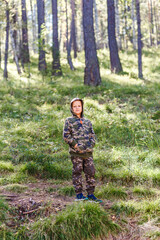 Fototapeta na wymiar boy in a camouflage suit in the autumn in the woods