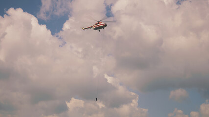 Firefighting helicopter in cloudy blue sky