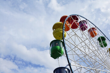 Ferris wheel against the blue sky. Colors of rainbow. Children's entertainment, leisure, recreation. - 454556273