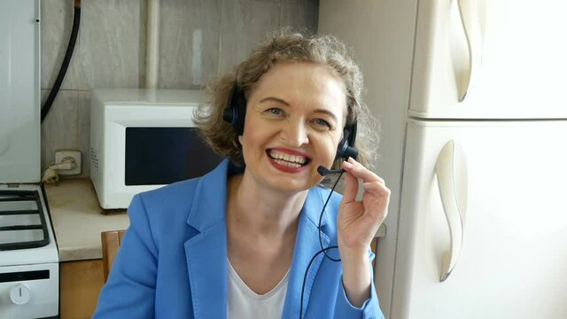 Female middle aged technical support agent working at home at kichen
