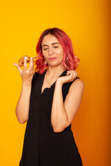 a girl of European nationality greedily looks at a piece of pizza wants to eat it on a yellow background with a place for the text