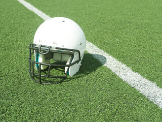 American Football helmet on field with yard lines