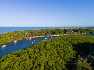 Vista aérea da vila de Caraíva em Porto Seguro, no sul da Bahia. Paraíso tropical com barcos e guarda-chuvas no pôr do sol tropical do Brasil.