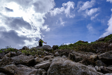 Escursionista sale la morena rocciosa verso il Lago delle Locce, parete Est del Monte Rosa