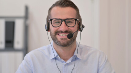 Portrait of Middle Aged Man with Headset Smiling at the Camera 