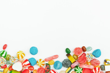 Multi-colored gummy candies on a white background. Festive frame backdrop.