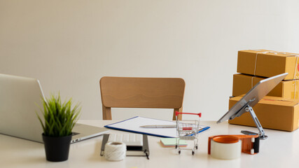 Start a sme business on desk with box and laptop with tablet and tool cart. online shopping and delivery ideas