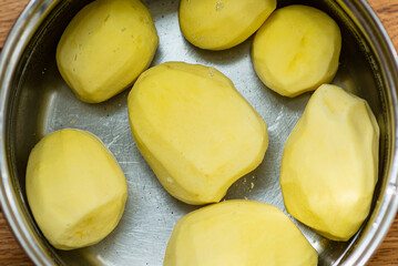 Peeled potatoes in a stainless pot of water.Potatoes peeled in water. Ingredients for soup.Raw potatoes peeled top view