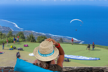 Femme observant des parapentes, île de la Réunion 
