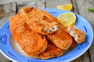  Fish and Chips/Close up of   crispy breaded  deep fried alaska pollock  fillets  with breadcrumbs served with remoulade sauce french fries  and   fresh lemons 