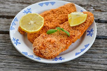  Fish and chips .Close up of   crispy breaded  deep fried fish fingers with breadcrumbs served with remoulade sauce and  lemon