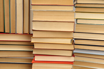 Many hardcover books as background. Library material