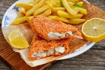  Fish and Chips.Close up of   crispy breaded  deep fried alaska pollock  fillets  with breadcrumbs served with remoulade sauce french fries  and  