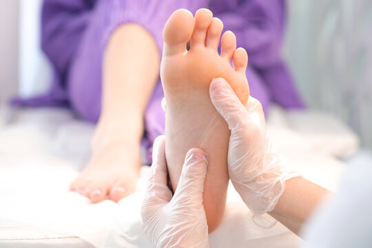 foot massage with hands in transparent gloves.