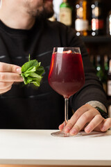 Bartender making Red Sangria in Italian restaurant. Sangria cocktail with red wine on bar blurred background