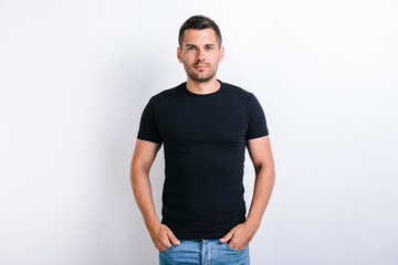 Portrait of happy smiley bearded man in black t shirt posing against white background. Male appearance concept. Studio shot