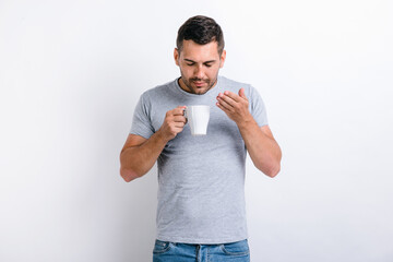Smells great. Waist up portrait view of the handsome man standing and sniffing aroma of the coffee...
