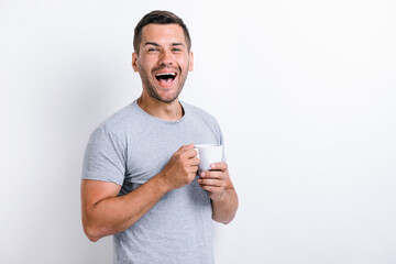 Waist up portrait view of the happy caucasian man standing and rejoicing with the cup of coffee....