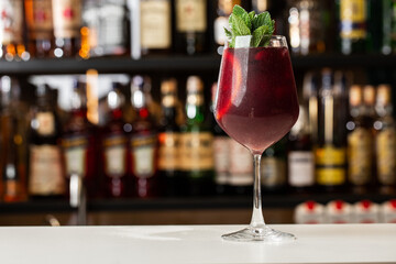 Closeup glass of red wine fresh sangria at bright bar counter background.