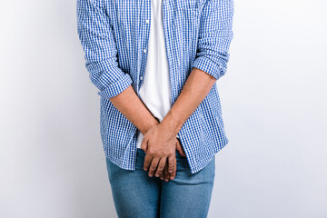 Cropped view of the man holding hands at the genitals while posing at the studio with white...