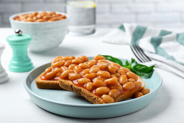 Toasts with delicious canned beans on white wooden table