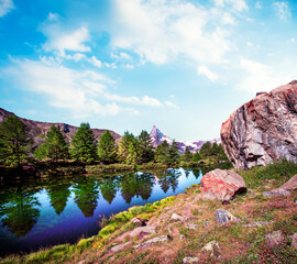 Magical beautiful landscape with a big rock near the lake and fir trees on background Matterhorn in the Swiss Alps, near Zermatt, Switzerland. Amazing places. (Meditation, antistress - concept).