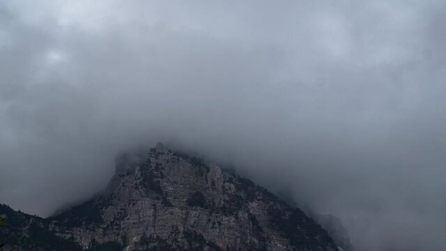 TIme lapse fog covering mountain top in the Albanian Alps. Clouds moving over the peaks of Valbone valley