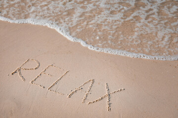 Word Relax written on sand at beach