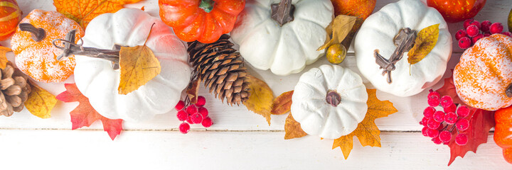 Thanksgiving day, Halloween festive geetiing card with pumpkins, decorative berries and autumn leaves on white wooden table copy space. Fall holiday flatlay copy space