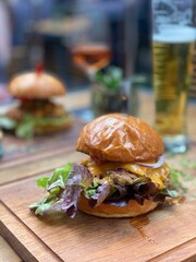 hamburger on a wooden table and beer on the background in restaurant