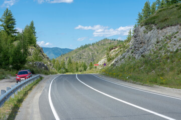 asphalt highway between rocks on a mountain pass. Russia, mountain Altai