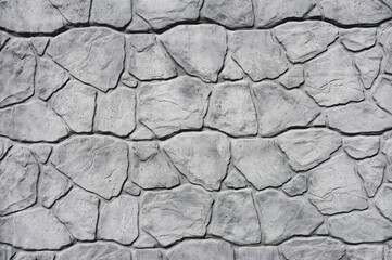 Close-up Gray concrete fence with imitation stone.