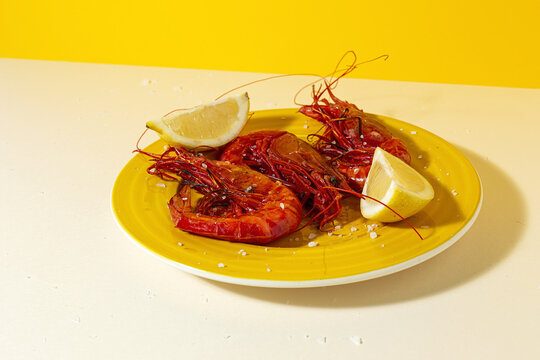 Scarlet shrimps with aromatic lemon pieces on plate
