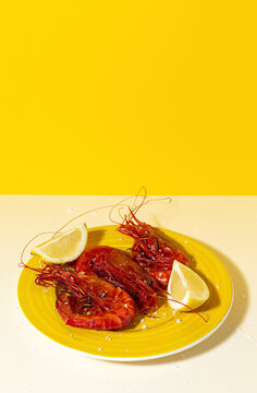 Scarlet shrimps with aromatic lemon pieces on plate
