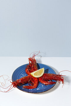 Scarlet shrimps with aromatic lemon pieces on plate