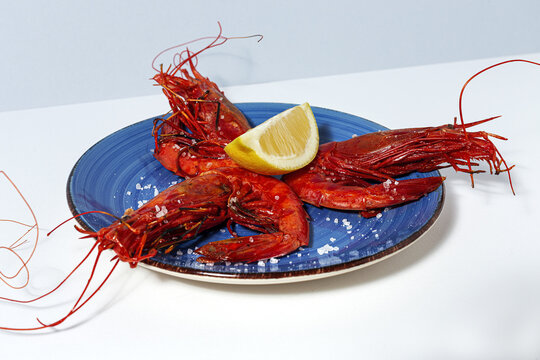 Scarlet shrimps with aromatic lemon pieces on plate