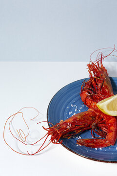 Scarlet shrimps with aromatic lemon pieces on plate
