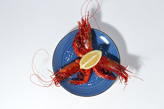 Scarlet shrimps with aromatic lemon pieces on plate